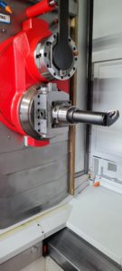 A red and metal part of a machining center that is used for completing various functions to machine parts, such as milling, drilling and more